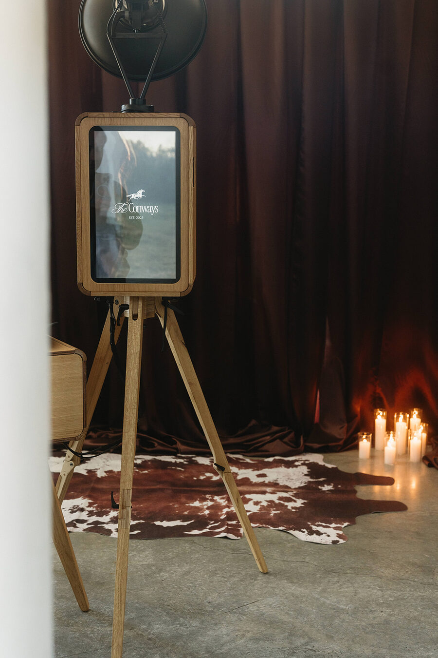Vintage wooden photo booth with touchscreen on a tripod stand